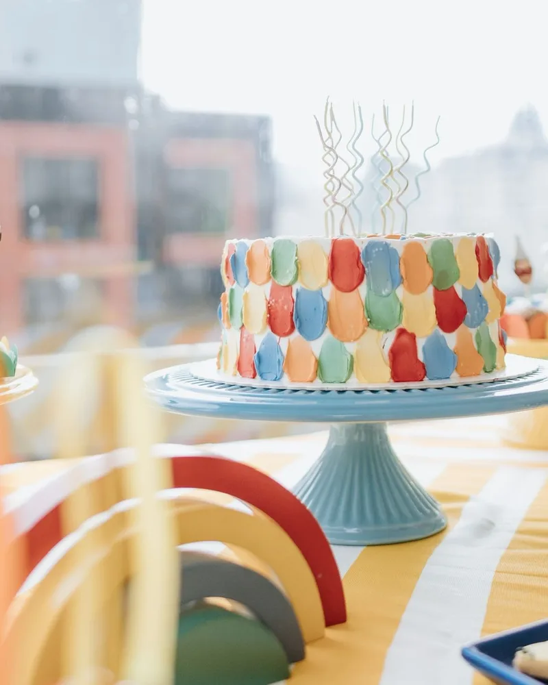 Bolo de aniversário com pinceladas coloridas e velas espirais em festa tema circo