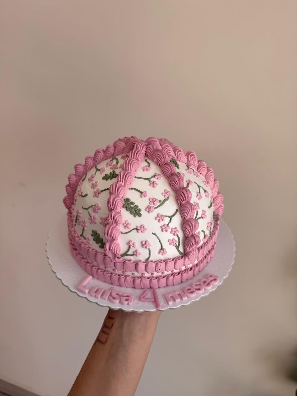 Bolo de mesversário rosa com flores de cerejeira modeladas à mão