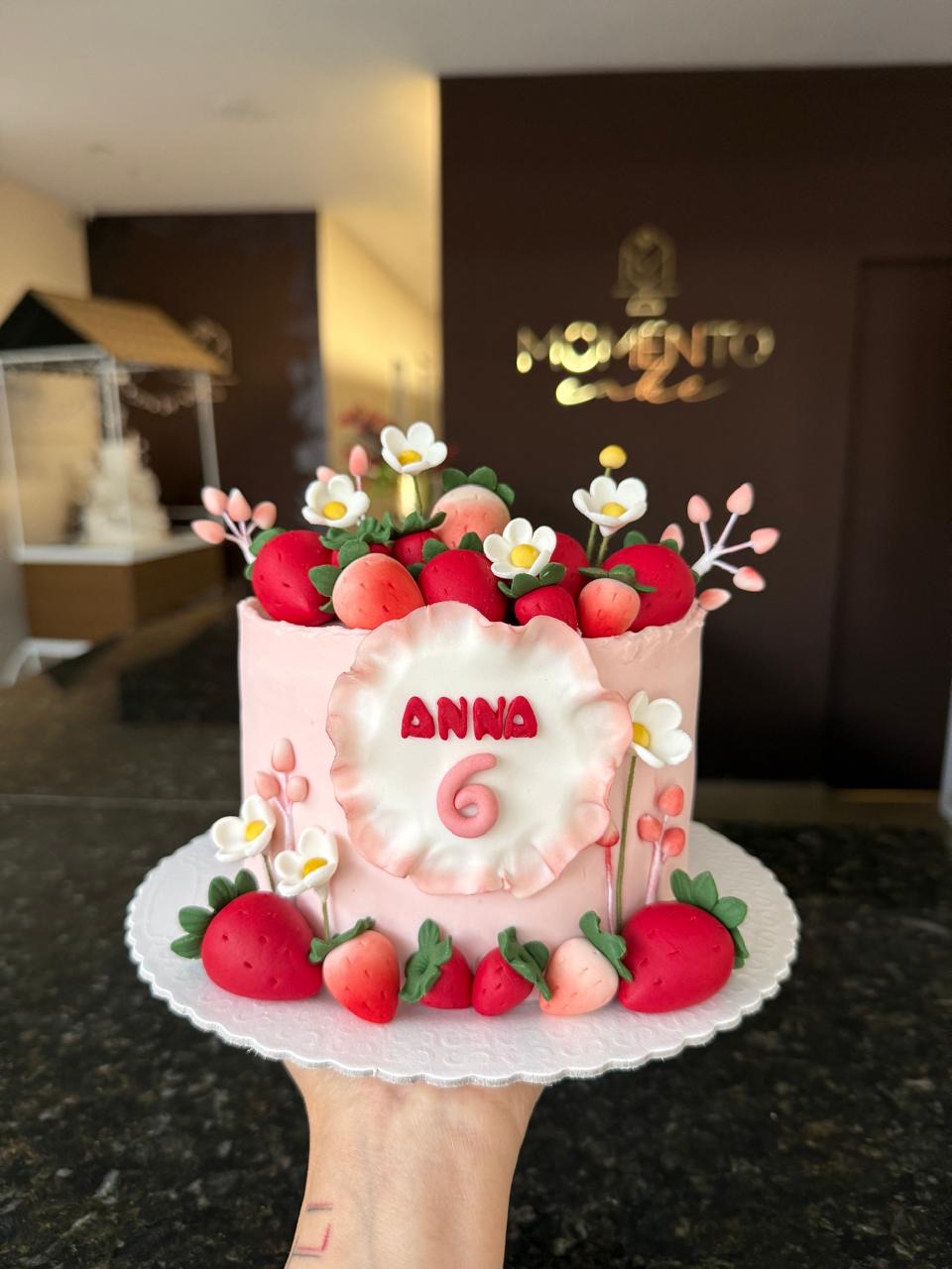 Bolo de mesversário rosa decorado com morangos de fondant